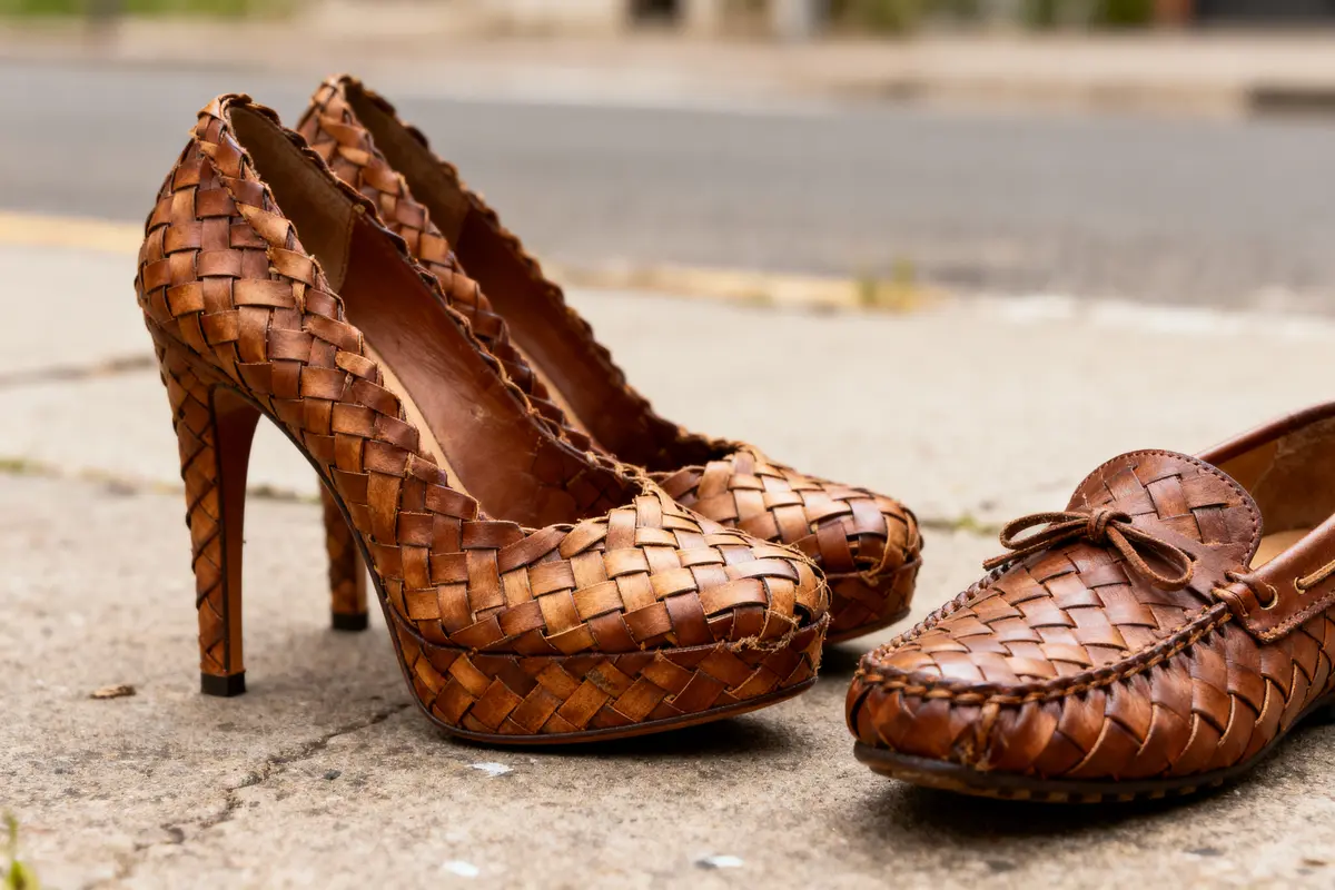 Chaussures en cuir tressé marron : escarpins à talons, mocassins, posés sur un trottoir extérieur.