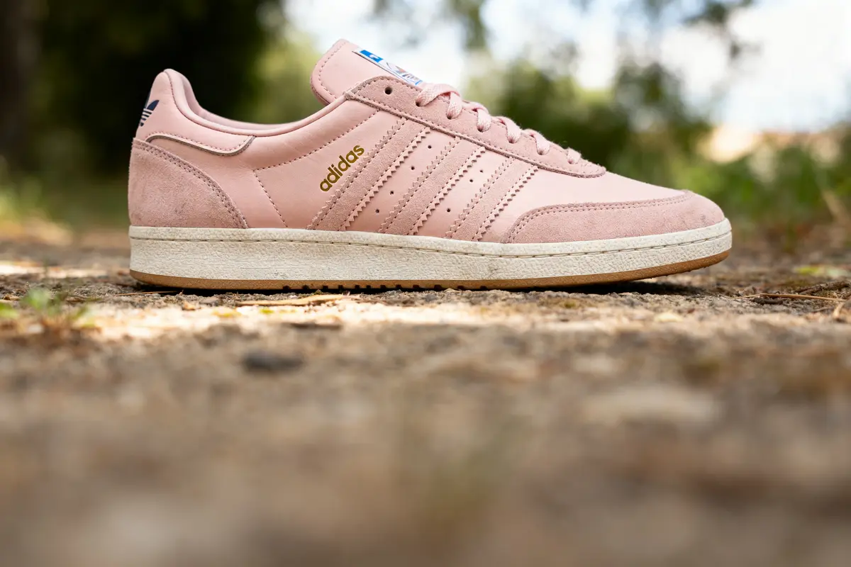 Chaussure Adidas rose Spezial posée sur un sol extérieur en gros plan