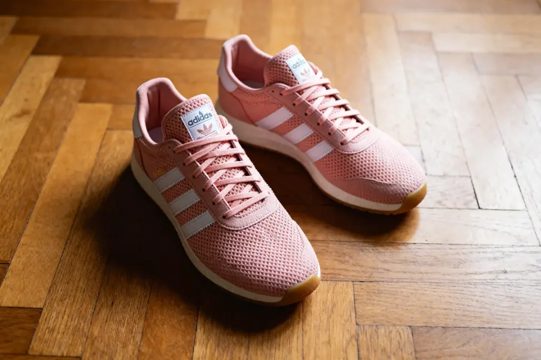Chaussures Adidas rose Spezial sur parquet en bois, vue de trois-quarts