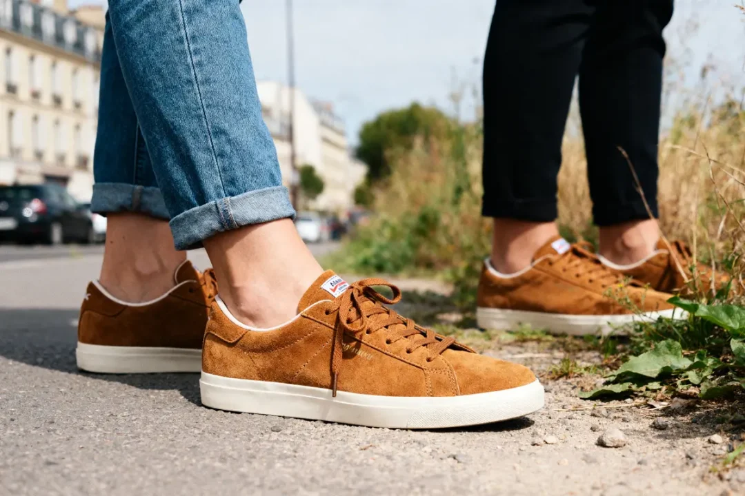Jeunes portant des baskets Campus marron femme sur un chemin urbain ensoleillé