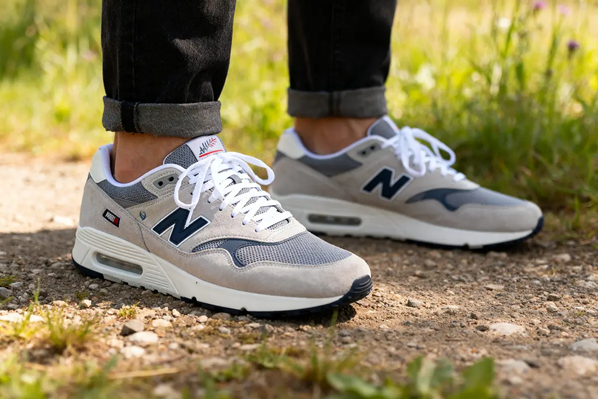 Homme portant des sneakers grises New Balance les plus confortables sur chemin gravillonné.
