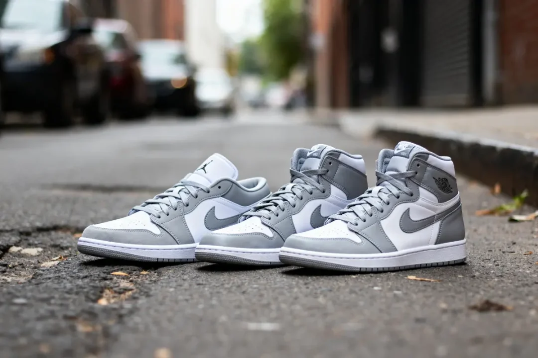 Chaussures Jordan 1 grises posées sur une rue urbaine avec arrière-plan flou