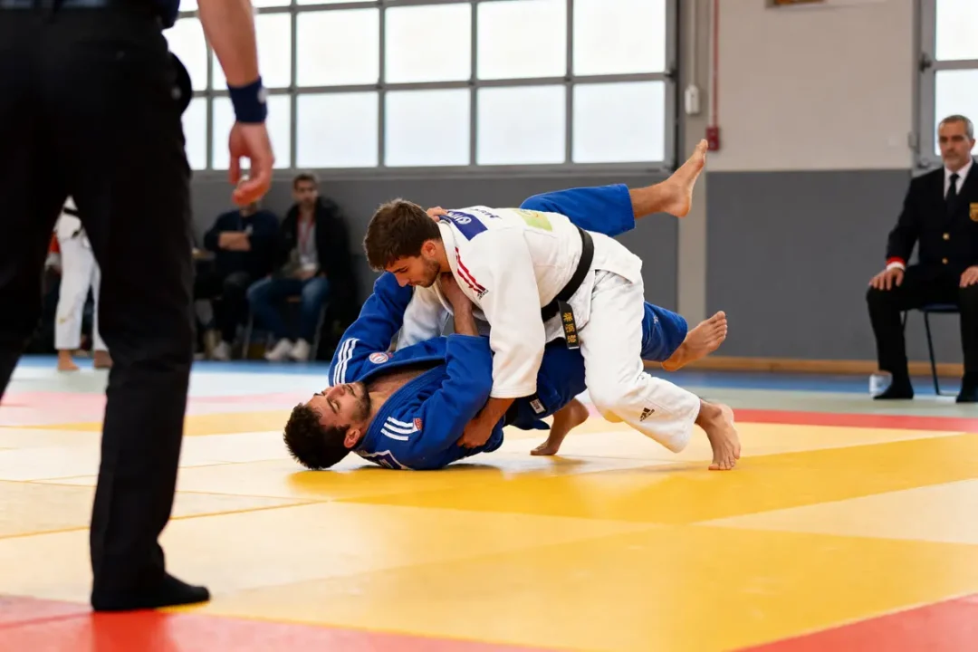 Deux judokas exécutent des prises de judo lors d'une compétition sur le tatami.