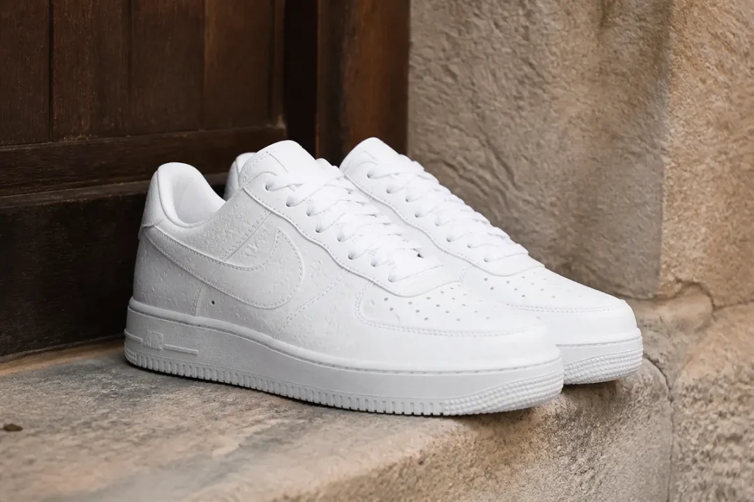 Chaussures blanches élégantes Air Force originales par Louis Vuitton posées sur une marche