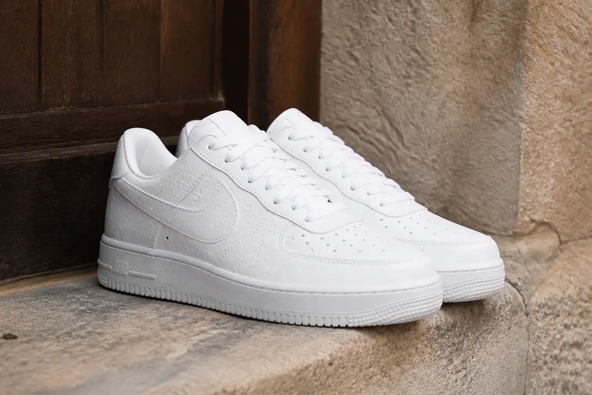 Chaussures blanches élégantes Air Force originales par Louis Vuitton posées sur une marche