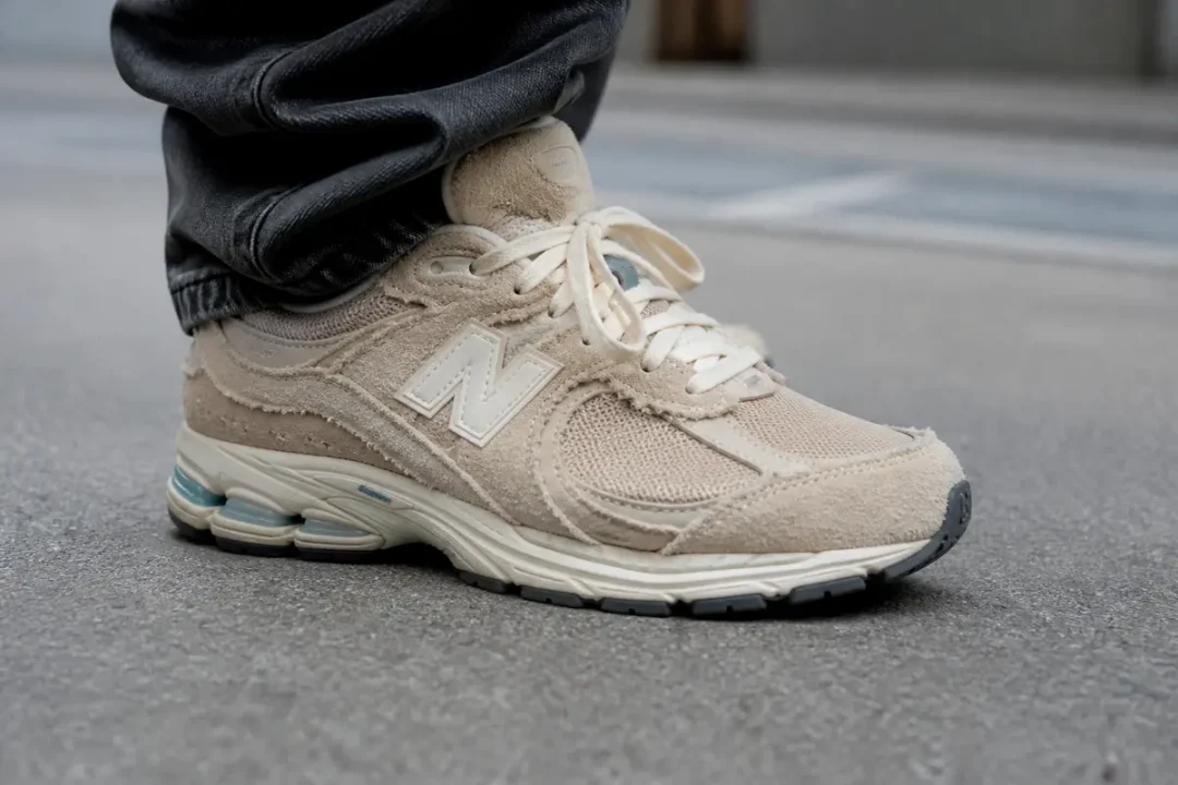 Chaussure New Balance 2002R Protection Pack beige sur du béton urbain